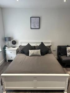 a large bed in a white room with a couch at Harrystoke 1 bedroom studio, free parking & Garden in Bristol