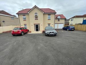 two cars parked in a parking lot in front of a house at Harrystoke 1 bedroom studio, free parking & Garden in Bristol