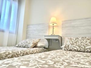 a hotel room with two beds and a window at Apartamento Puerta Cerrada in Écija +22 photos
