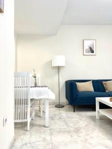 uma sala de estar com um sofá azul e uma mesa em Apartamento Puerta Cerrada em Écija