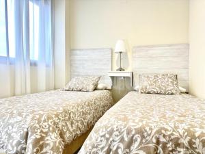 two beds sitting next to each other in a bedroom at Apartamento Puerta Cerrada in Écija