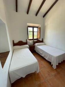 - 2 lits dans une chambre avec fenêtre dans l'établissement Casa rural Los Caballos Finca Los Pelaeros Alora Caminito del Rey, à Alora