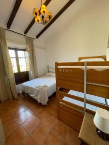 a bedroom with two bunk beds and a chandelier at Casa rural Los Caballos Finca Los Pelaeros in Alora