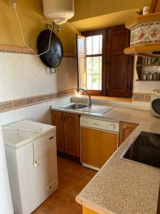 La cuisine est équipée d'un évier et d'un réfrigérateur blanc. dans l'établissement Casa rural Los Caballos Finca Los Pelaeros Alora Caminito del Rey, à Alora