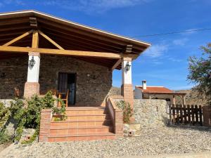 une maison en pierre avec un toit en bois dans l'établissement Casa rural Los Caballos Finca Los Pelaeros Alora Caminito del Rey, à Alora