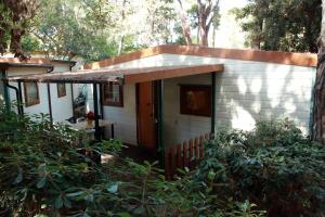 a small white house with an awning at Camping Village Free Time in Marina di Bibbona