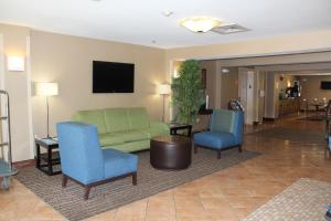 a living room with a green couch and two blue chairs at Quality Inn Raleigh Downtown in Raleigh