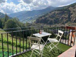 een tafel en 2 stoelen op een balkon met uitzicht op de bergen bij FONTARGENT 3 in Soldeu
