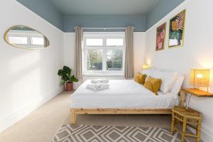 Un dormitorio con una cama grande y una ventana en 1 Min to Beach, 8 Guests, Garden, Snug, Parking - Azure House en Bournemouth