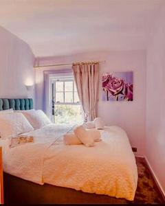 a bedroom with a large white bed with a window at Lilac Cottage Morpeth Northumberland in Morpeth