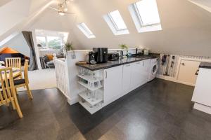 a kitchen with white cabinets and a counter top at 1 Min to Beach, 8 Guests, Garden, Snug, Parking - Azure House in Bournemouth