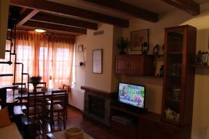 sala de estar con TV y comedor en APARTMENTSUITESPAIN BAQUEIRA JARDIn, en Esterri d'Àneu