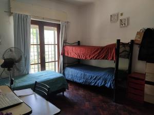 1 Schlafzimmer mit 2 Etagenbetten und einem Schreibtisch in der Unterkunft HA! 2 Resi para estudiantes in Cordoba