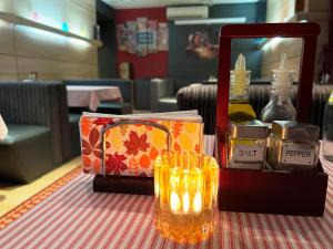 a table with a bottle of perfume and a candle at Hotel Dunav in Vidin