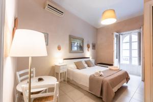 a bedroom with a bed and a table and a lamp at Dedalo Rooms in Noto
