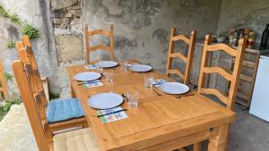 Châteauneuf-les-Bains的住宿－Villa Guillaumette，一张木桌,上面有盘子和玻璃杯