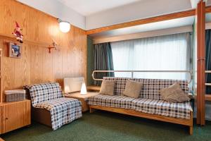 a living room with a couch and a chair at Appartamento Nives in Marilleva +21 photos