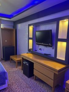 een kamer met een flatscreen-tv aan de muur bij Ünaten otel in Gaziemir