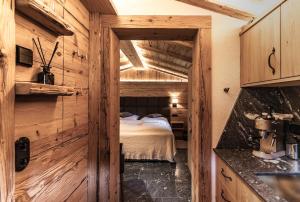a bedroom in a log cabin with a bed in it at Bärenbach - Almhütte Saalbach in Saalbach Hinterglemm