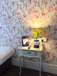 a bedroom with a table with a lamp on it at The Boho - 4 min walk to beach & town in Bournemouth