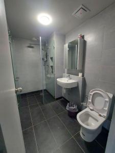 a bathroom with a toilet and a sink and a shower at Jesselton Quay Seaview Homestay with free 1 parking by StayPlace in Kota Kinabalu