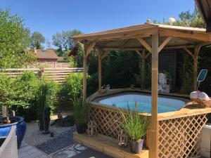 a hot tub in a wooden gazebo at Chalet La Romance in Prouilly