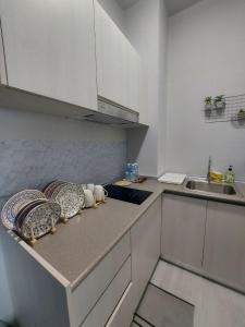 a kitchen with white cabinets and a counter top at Jesselton Quay Seaview Homestay with free 1 parking by StayPlace in Kota Kinabalu