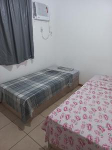 a bedroom with two beds and a air conditioner at Apartamento Chapada Diamantina in Cuiabá