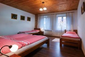 1 dormitorio con 2 camas y ventana en Chaty Ski Telgárt, en Telgárt