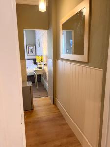 a hallway with a room with a bed and a mirror at The Boho - 4 min walk to beach & town in Bournemouth