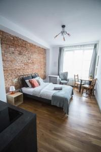 a room with a bed and a brick wall at LION apartments - SILVER in Kraków