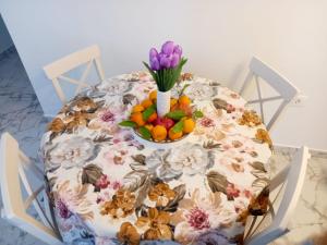 een tafel met een kom bloemen en een kom fruit bij Amellia in Ljubuški