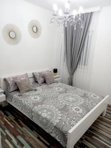 een slaapkamer met een bed met een kroonluchter bij Amellia in Ljubuški