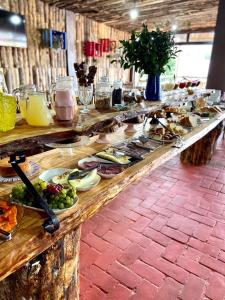una línea de buffet con diferentes tipos de comida. en Pousada Refúgio do Sol, en Cambará