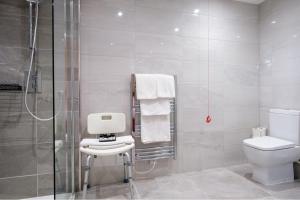 a bathroom with a toilet and a shower at Best Western Lichfield City Centre The George Hotel in Lichfield