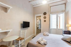 a bedroom with a bed and a table and a tv at Dedalo in Noto