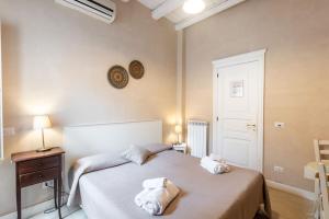 a bedroom with a bed with towels on it at Dedalo Rooms in Noto