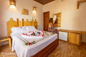 a woman standing next to a bed with a cake on it at Island Holiday Lodge in Keyodhoo