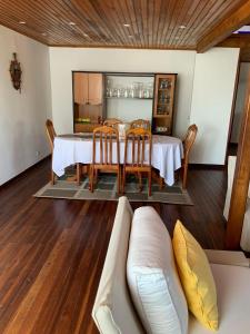 uma sala de jantar com uma mesa e cadeiras e um sofá em Villa Eden Wood em Ivato