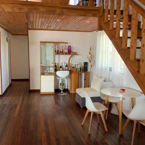 een woonkamer met een trap en een tafel en stoelen bij Villa Eden Wood in Ivato