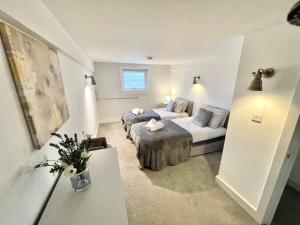 a hotel room with two beds and a couch at Fantastic convenient 2 Bedroom 2 bathroom Perfect for Stansted Airport, 3 minute walk to Bishops Stortford Train Station! in Bishops Stortford
