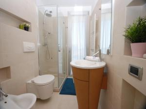 a bathroom with a sink and a toilet and a shower at Residenza Ore Felici in Lignano Sabbiadoro