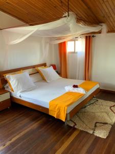 Łóżko w pokoju z drewnianą podłogą w obiekcie Villa Eden Wood w mieście Ivato
