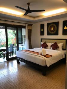 a bedroom with a large bed with a ceiling fan at Arina Boutique Residence in Chaweng