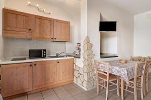 a kitchen with wooden cabinets and a table with chairs at Appartamento Camelia in Pietra Ligure