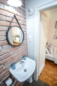 W łazience znajduje się biała umywalka i lustro. w obiekcie LION apartments - Gold w Krakowie
