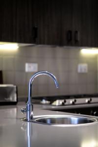 a kitchen sink with a faucet on a counter at Abdali Views Apartments in Amman