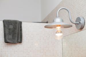 a light in a bathroom with a towel on a wall at Apartment Aptucat in Barcelona