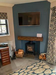 a living room with a fireplace and a flat screen tv at Old Manse Cottage in Durness