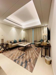 a living room with a couch and a table at Ocean Mountain View Apartment at The Address Fujairah in Fujairah